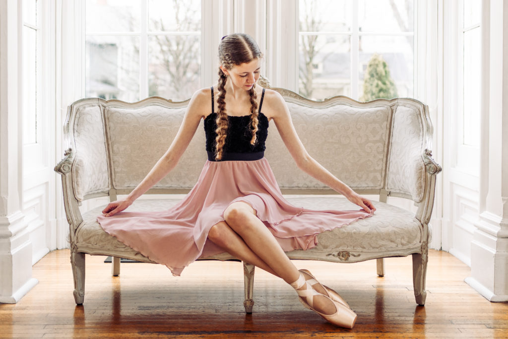 ballerina sitting on a sofa looking at skirt