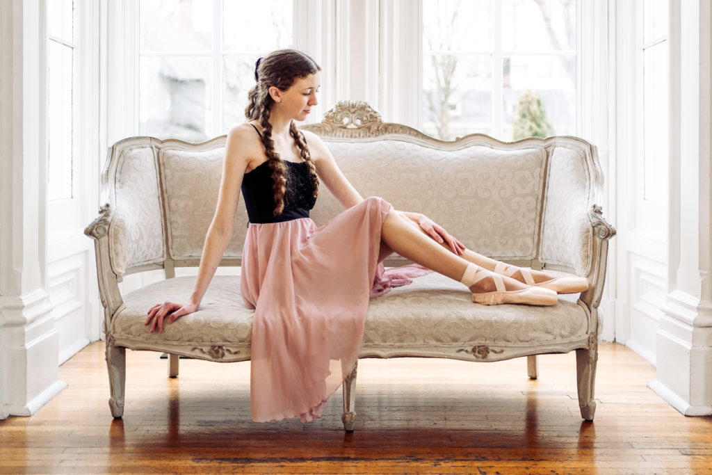ballerina sitting on sofa looking at shoes