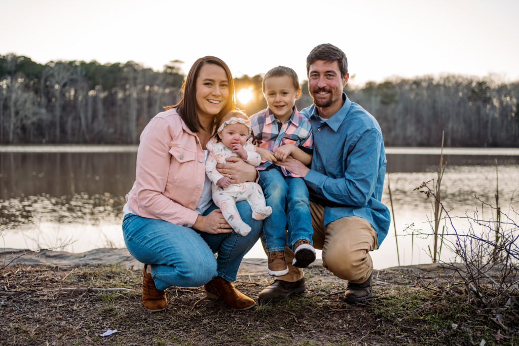 family of four in front of lake