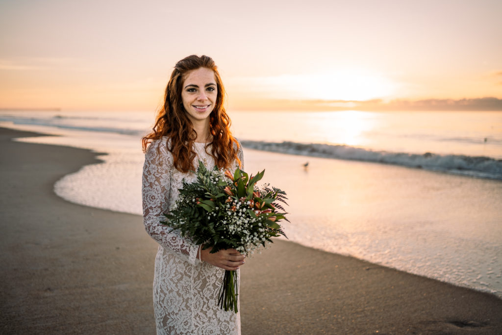 bride smiling with bouquet on Topsail Island at Sunrise
