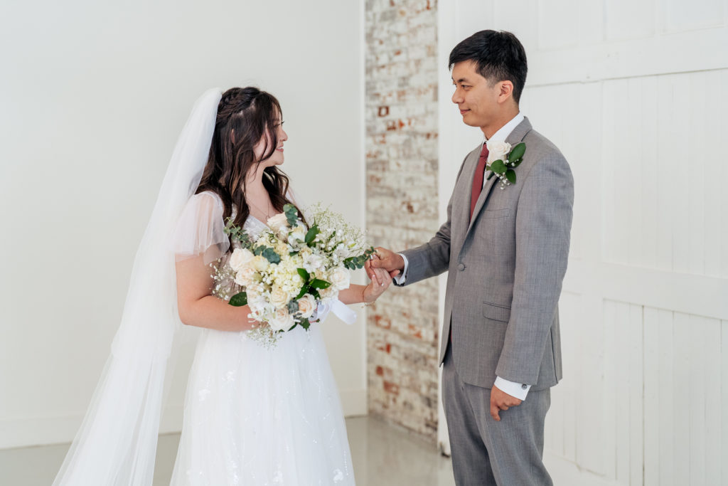 bride and groom smile at each other during first look