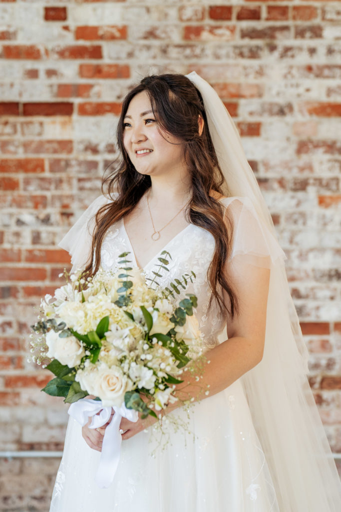 bride holds bouquet and looks into the distance