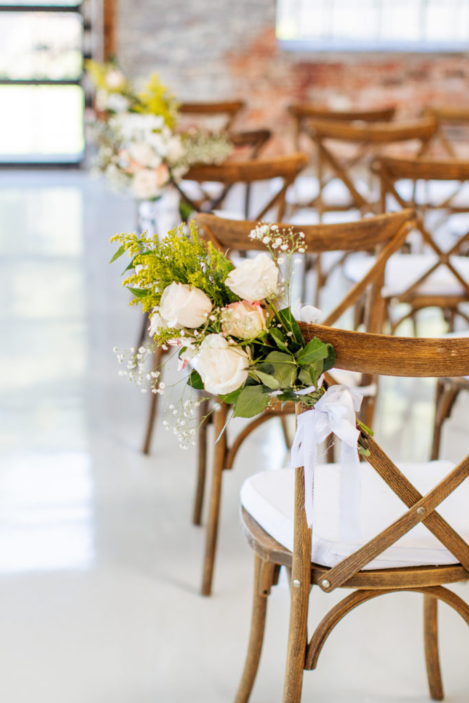 floral bouquet attached to back of wedding ceremony chair
