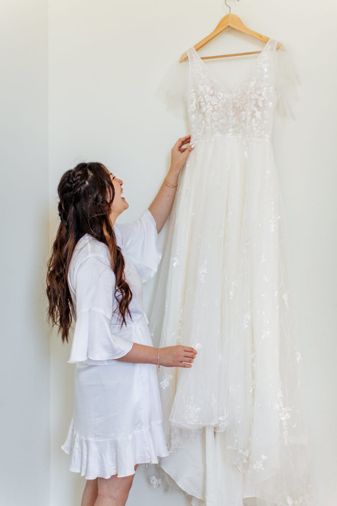 bride touching and looking at her wedding dress