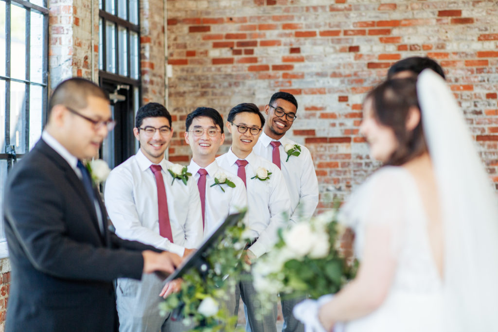 groomsmen smiling during the wedding ceremony