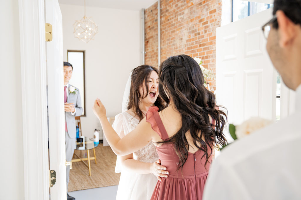 bride cheering with maid of honor in dressing room after the ceremony