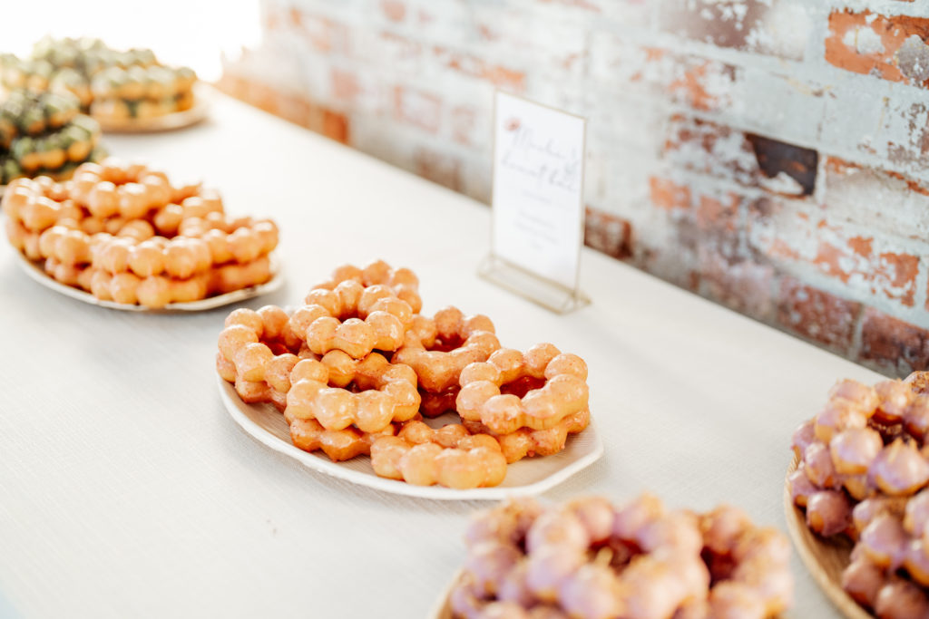 mochi donuts sit on plates on table at a wedding
