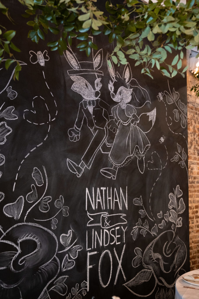 chalk wall drawing of bride and groom foxes