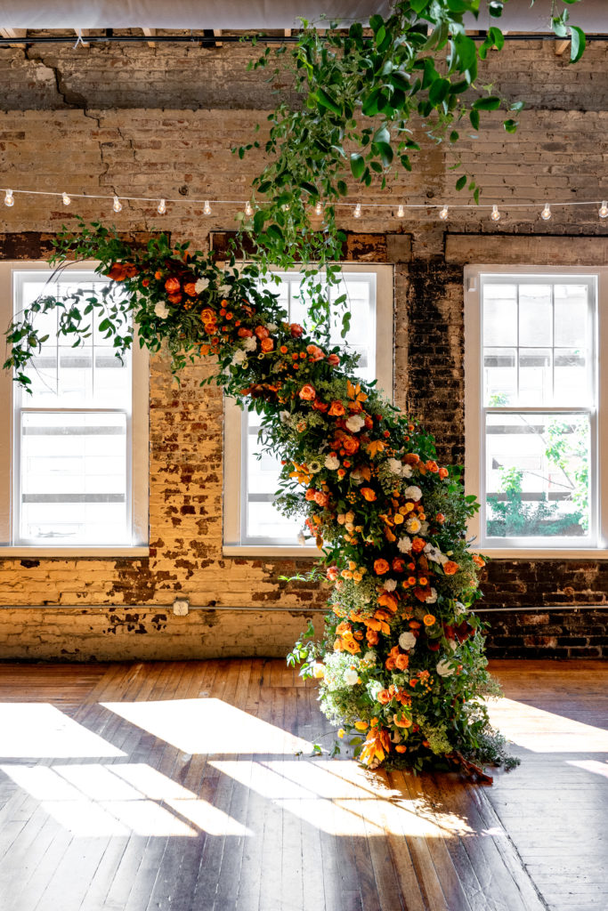 floral arch set up in front of large windows