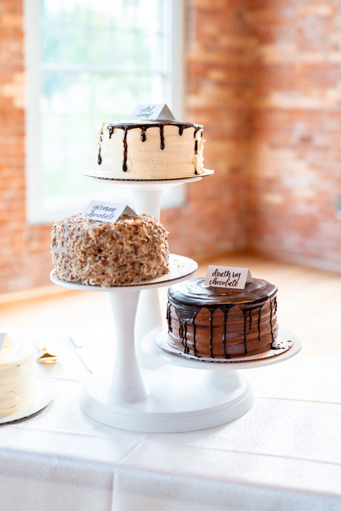 three small wedding cakes set on display stands