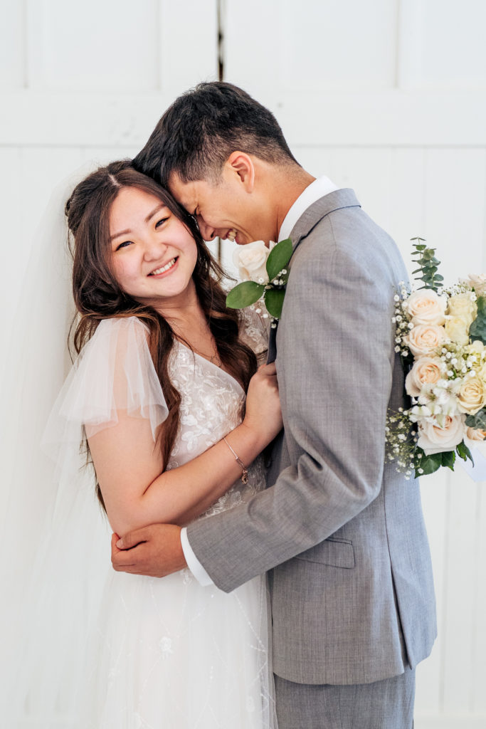 stress-free wedding day bride and groom hold each other and smile 