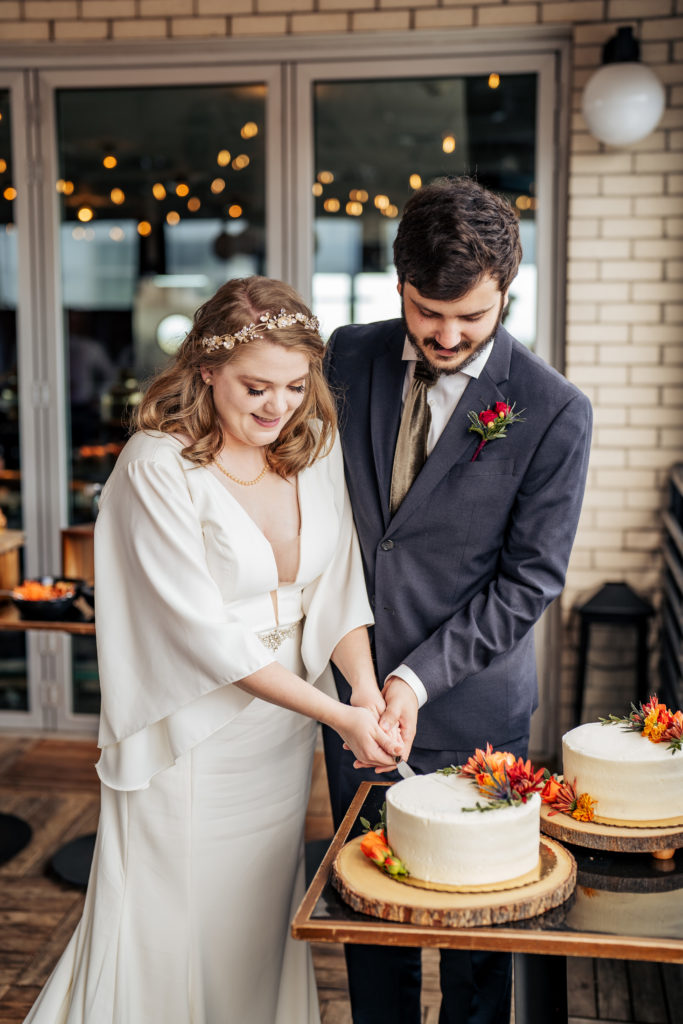 bride and groom cut the cake at the Durham Hotel rooftop wedding