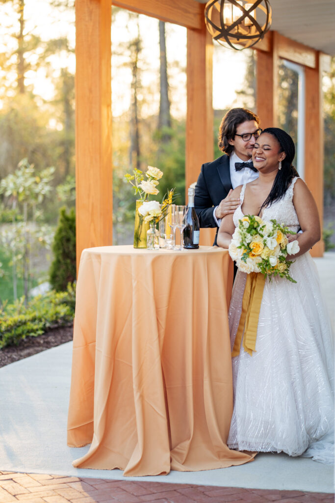 groom whispers in brides ear during golden hour porait
