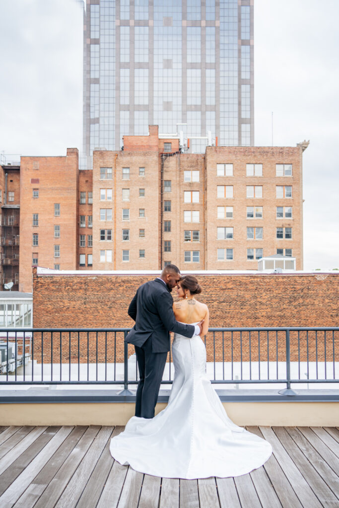 bride and groom in front of downtown buildings at the Stockroom at 230 in downtown Raleigh