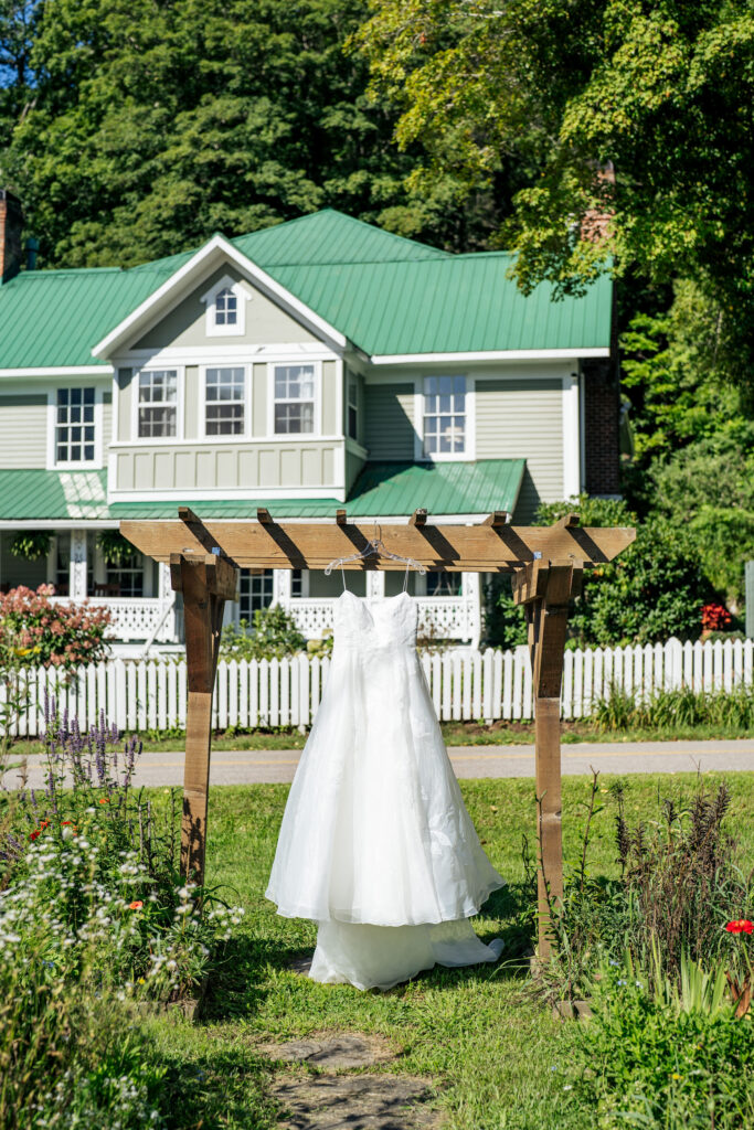Wedding dress hangs in the garden wedding at the Mast Farm Inn in Boone, NC