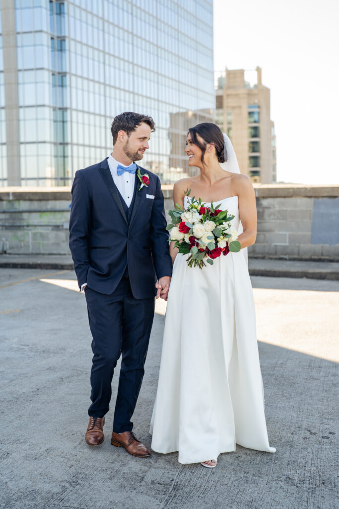bride and groom hold hands on a parking deck in Raleigh, NC