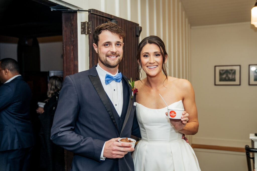 bride and groom hold Two Roosters ice cream cups at All Saints Chapel
