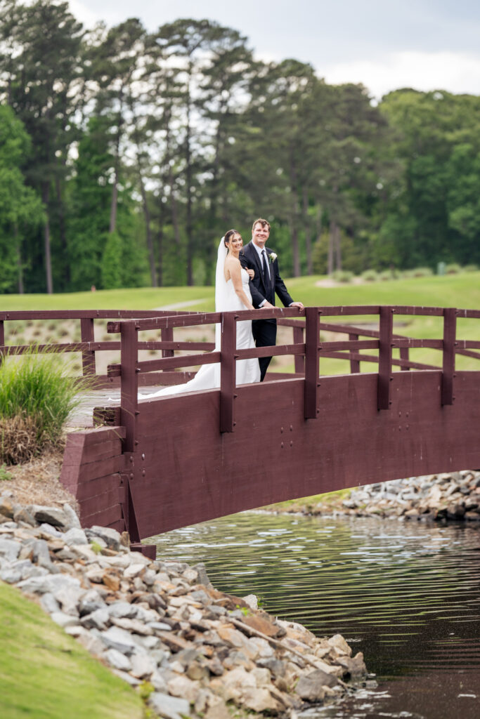 bride and groom smile on bridge at MacGregor Downs Country Club