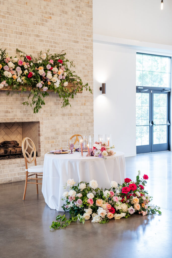 wedding reception details including sweetheart table and colorful floral arrangements