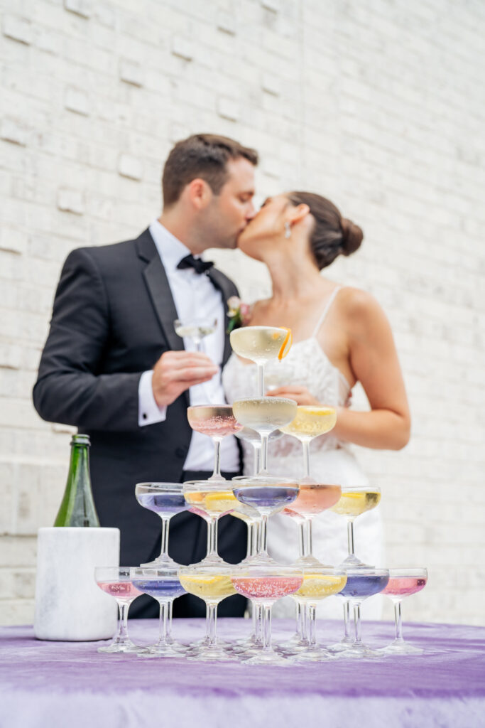 bride and groom kiss behind cocktail tower at Raleigh wedding