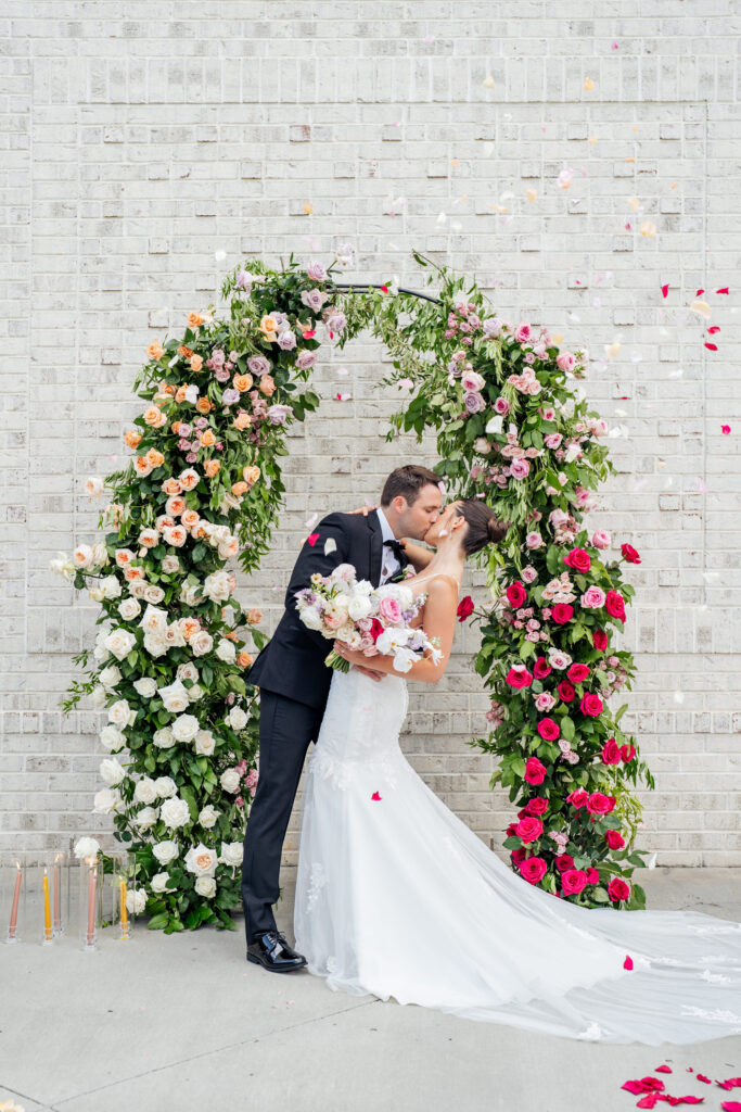 bride and groom kiss at wedding ceremony during flower petal toss at the Maxwell