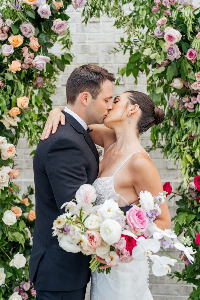 bride and groom kiss at wedding ceremony at the Maxwell in Raleigh, NC