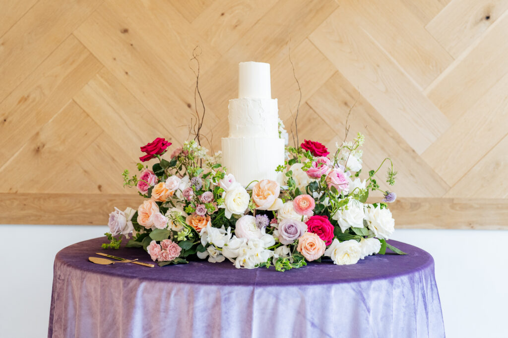 white cake with floral cake meadow at Raleigh wedding venue