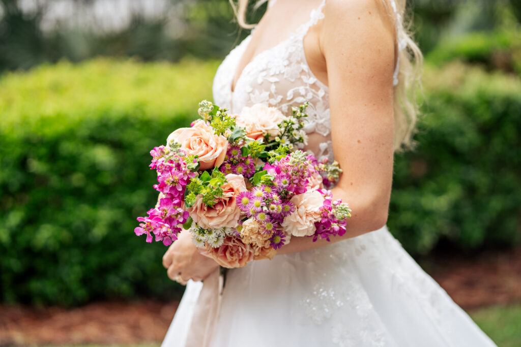 Bride holding pink and peach floral bouquet