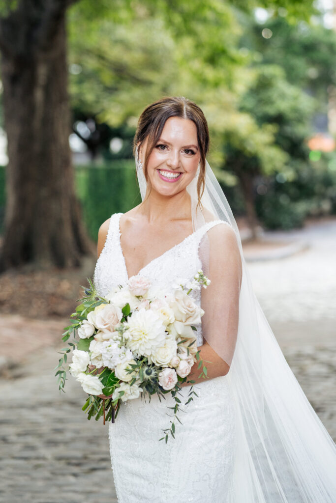 bride smiling for portrait holding flowers