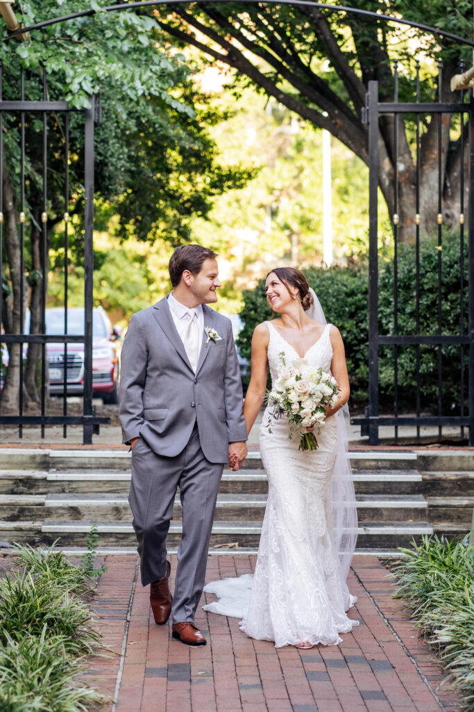 bride and groom walking and holding hands at City Market in downtown Raleigh