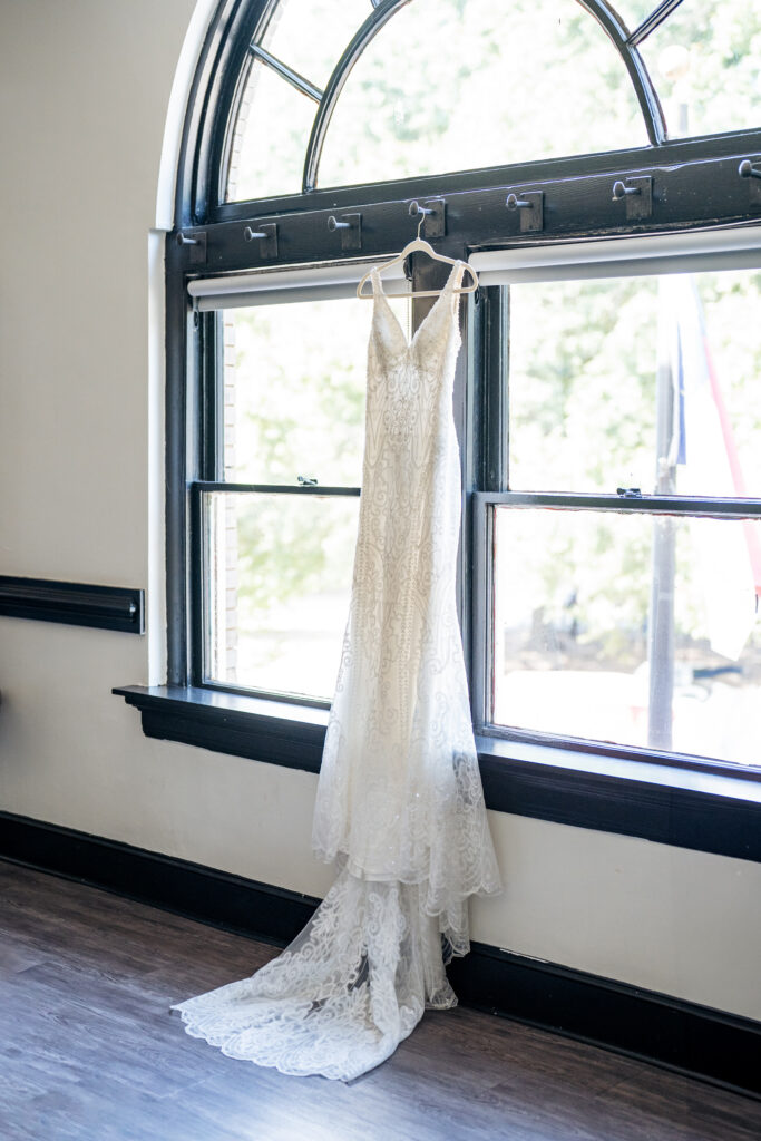 wedding dress hanging in window at Market Hall