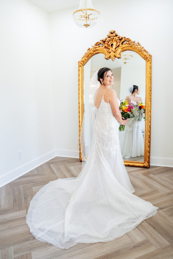 bride holding flowers in front of mirror at bridal suite at Daniel's Ridge wedding venue