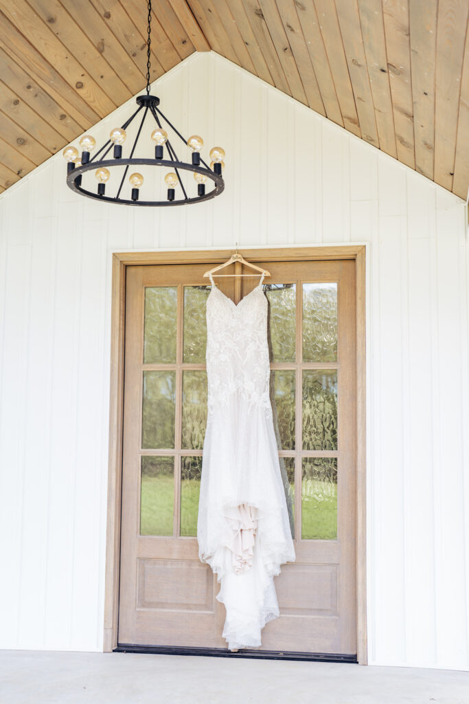 bridal gown hanging from door at Daniel's Ridge wedding venue