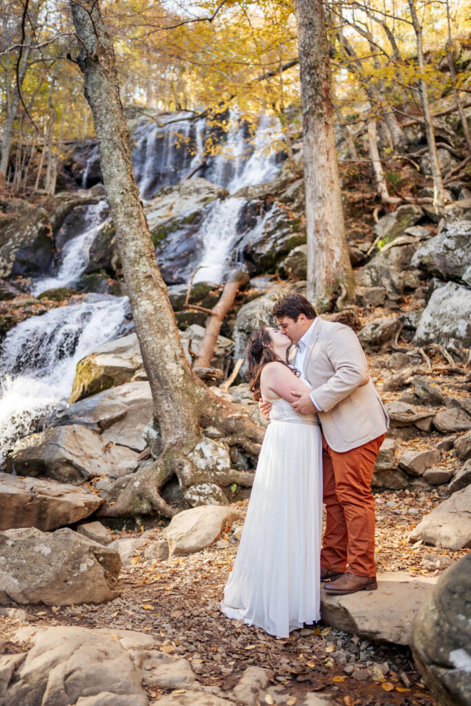 bride and groom kiss in front of Dark Hollow Falls in Shenandoah National Park