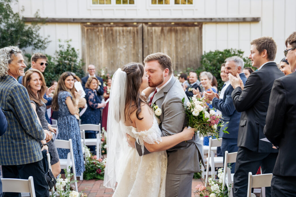 bride and groom kiss at wedding ceremony