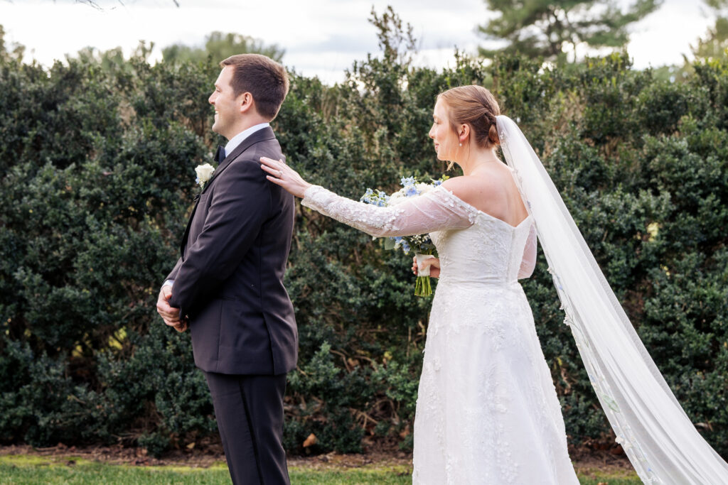 bride taps groom on shoulder during first look