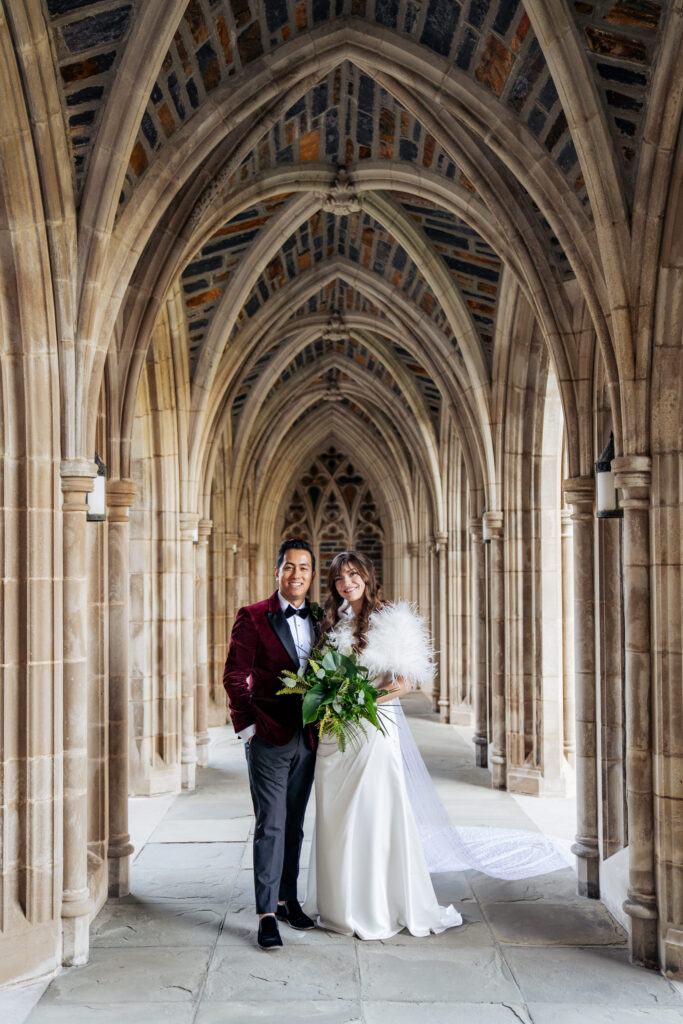 bride and groom smile for picture at Duke Chapel