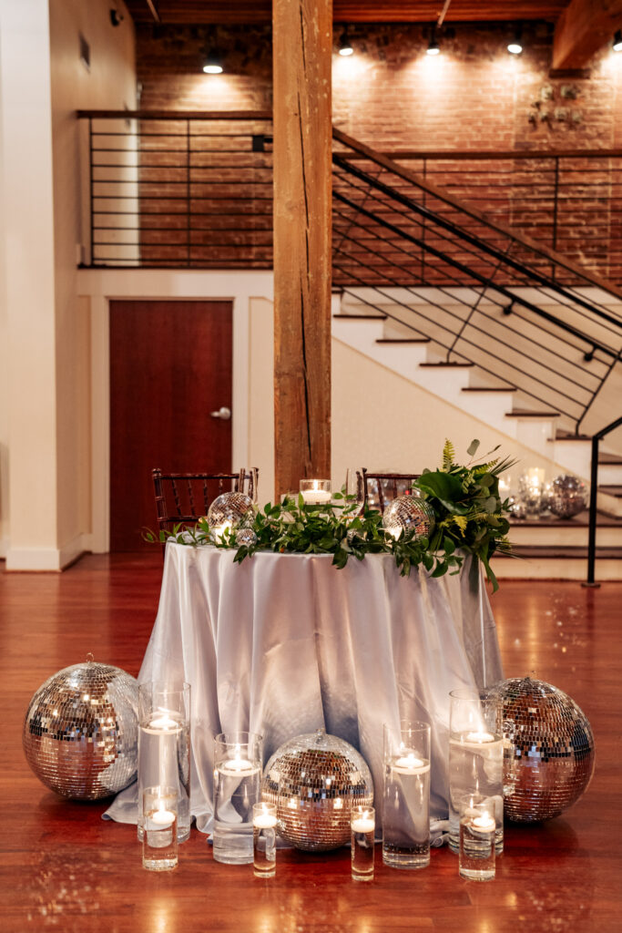 sweetheart table at wedding reception with disco balls