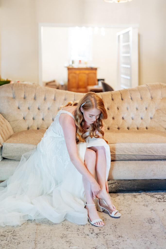 bride putting on her shoes in the bridal suite at traine at seaboard station