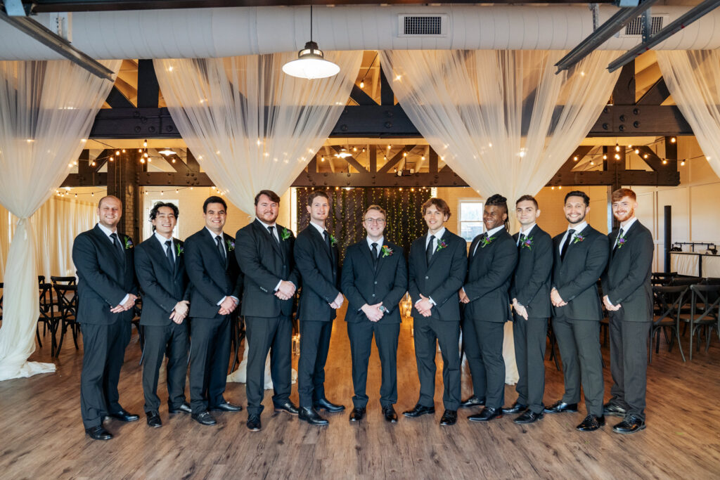 groomsmen lined up for a photo at the front of the venue