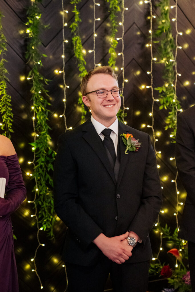 groom watches bride walk down the aisle