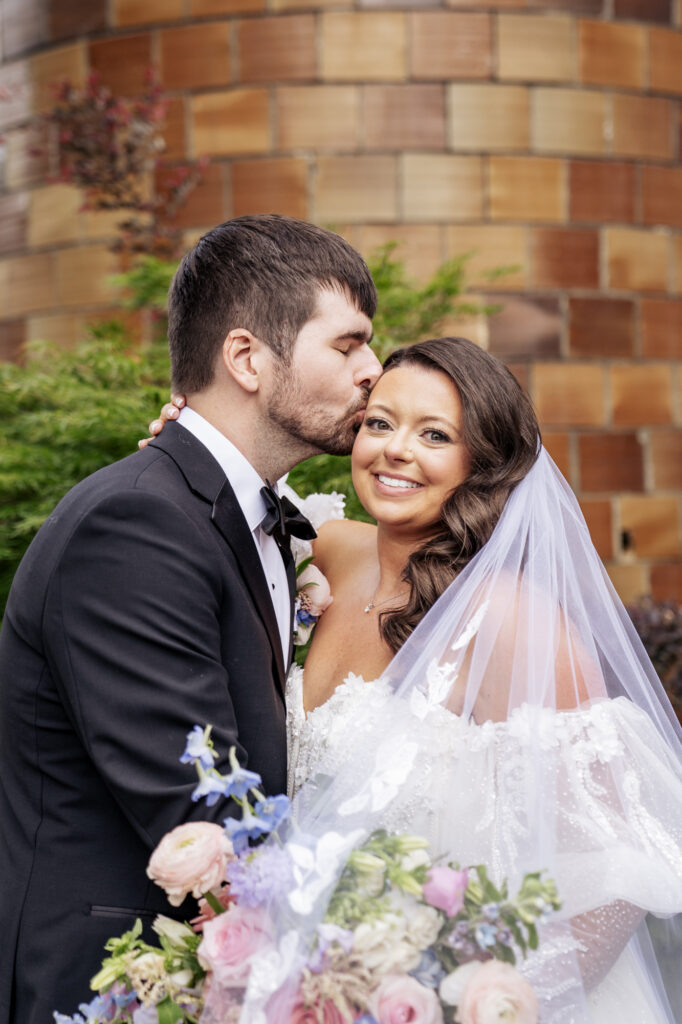 groom kisses bride on cheek at Historic Wakefield Barn wedding