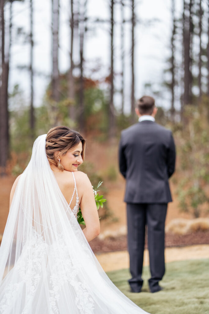 bride looks over shoulder before first look at the Upchurch wedding venue