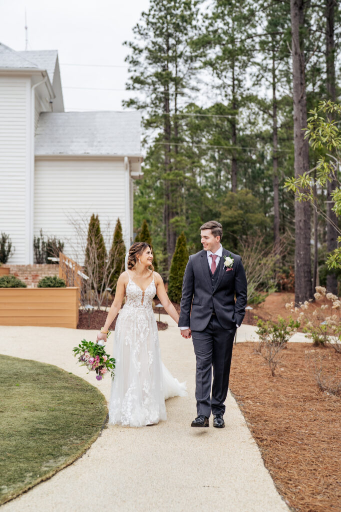 bride and groom hold hands and walk at the Upchurch