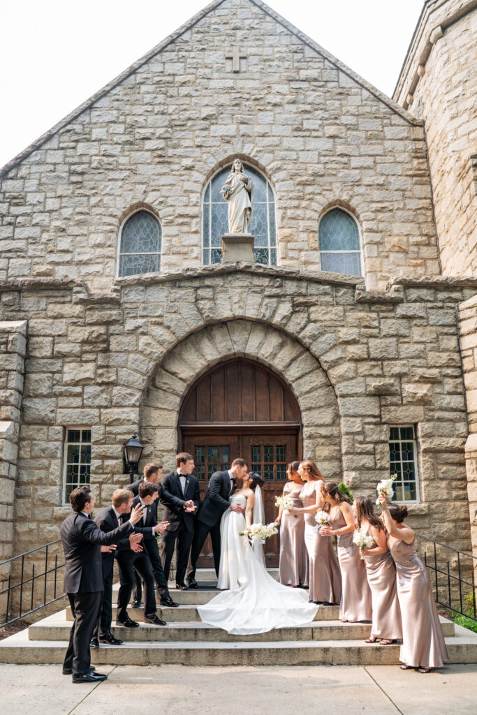 wedding party cheering on front steps of Sacred Heart church