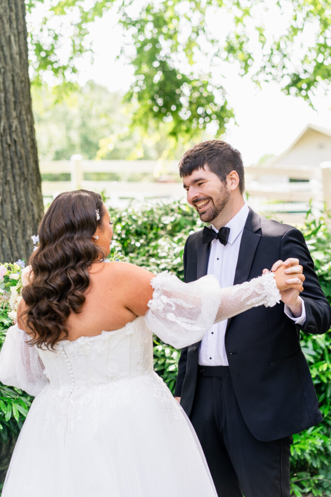 groom smiles seeing bride during first look at Historic Wakefield Barn near Raleigh, NC