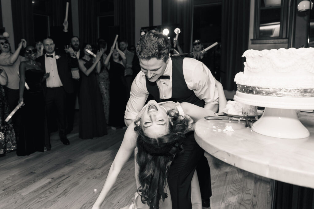 Groom dips bride on the dance floor at wedding at Bridge Club in downtown Raleigh