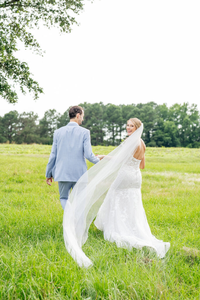 bride looks over shoulder at Raleigh wedding photographer for candid photo